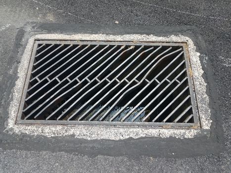black asphalt and metal drain drainage grate or bars