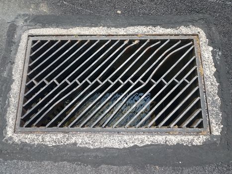 black asphalt and metal drain drainage grate or bars