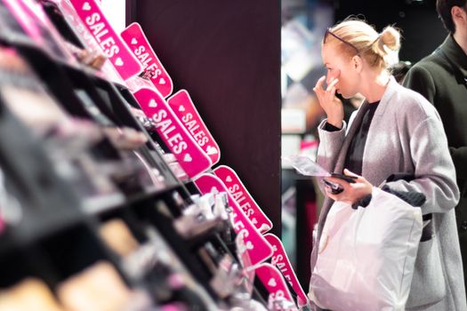 Women buying and testing cosmetics in a beauty store.