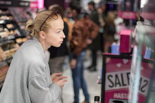 Women buying and testing cosmetics in a beauty store.