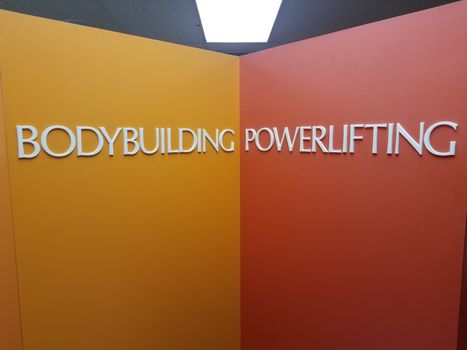 yellow and orange bodybuilding and powerlifting sign on wall