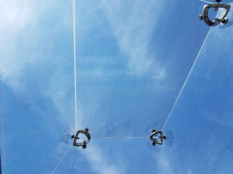 view of blue sky and clouds from clear ceiling from inside transparent glass box