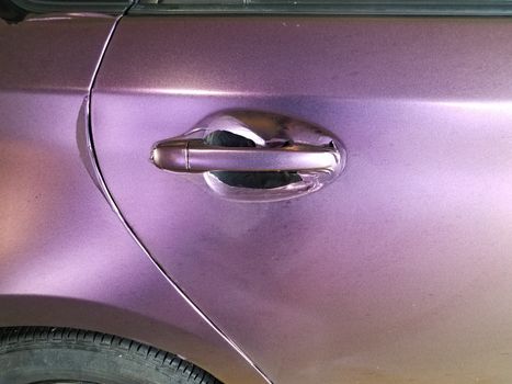 worn or damaged purple wrap on automobile with door handle