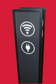 Stand tower for charging mobile phones in shopping Mall, wifi zone sign isolated on red background by clipping, vertical shot.