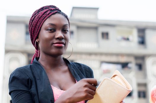 smiling young woman removing money from her purses.