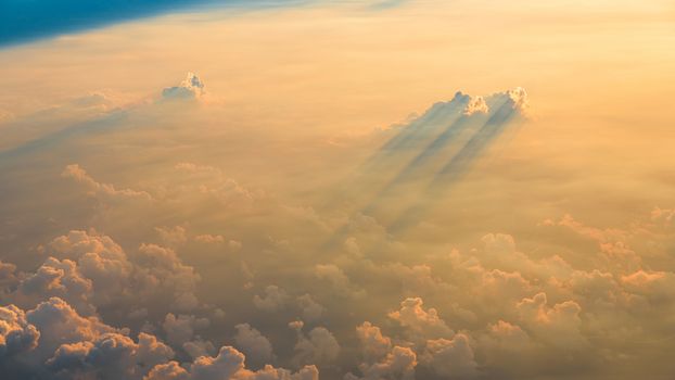 Beautiful aerial view of clouds at sunset, some clouds projecting dramatic shadows. View from airplane.