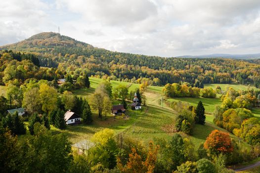 Autumn colorful landscape with forests, hills, sun and sky