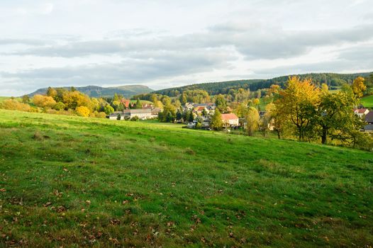 Autumn colorful landscape with forests, hills, sun and sky