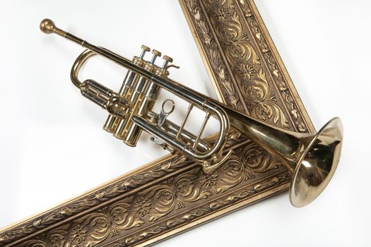 Trumpet and golden frame on an isolated studio background