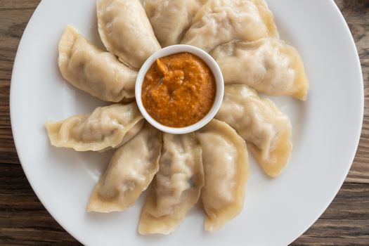 Plate of Nepalese chicken momos and its achar (sauce)