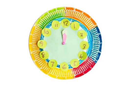 Colorful child handwork clock pointing at 12 o'clock, isolated on white background