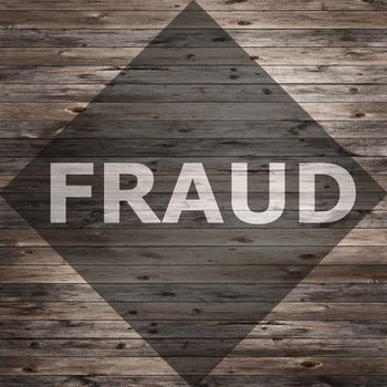 Fraud text on seasoned wood background.