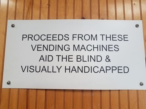 proceeds from vending machines aid the blind and visually handicapped sign on wood wall