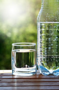 Cold mineral water against nice green nature background