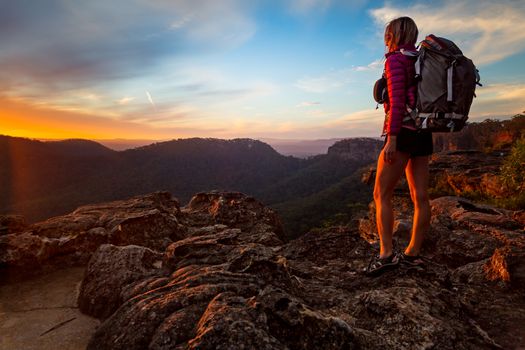 Female hiker  on bushwalk in upper Blue Mountains, watching a sunset from the peak