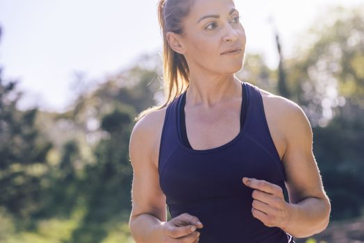 portrait of beautiful sports woman running during outdoor workout at the park at the morning with sunlight, sport and healthy lifestyle concept