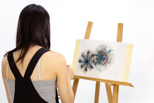 Over the shoulder shot of artist painting on easel