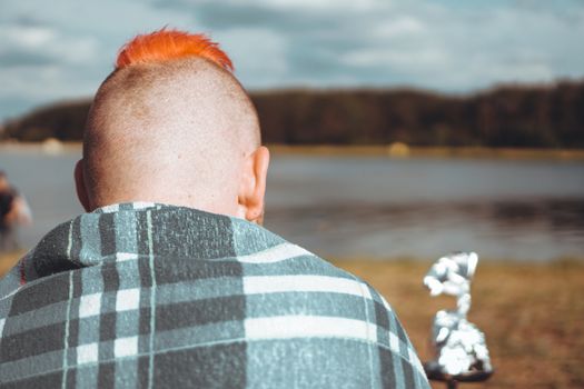 Summer vacation, activity. environment, travel and hookah smoking concept. Hipster traveler with red hair smoking a hookah in nature