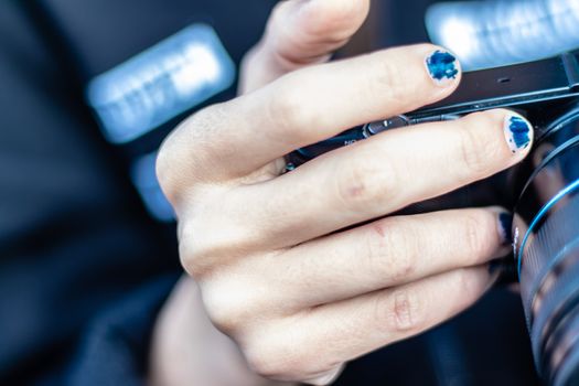 a girl with scratched nail polish holding a camera from sides. photo has taken at izmir/turkey.