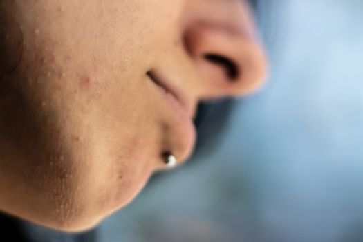 face expression from a black haired girl with metal chin piercing - background is blurry. photo has taken at izmir/turkey.