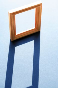 Empty wooden frame with long shadow against sunlight