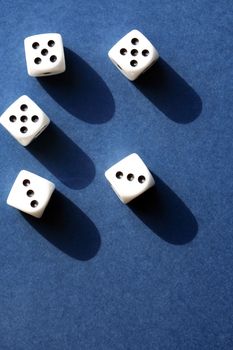 Few dice cubes on blue background with free space
