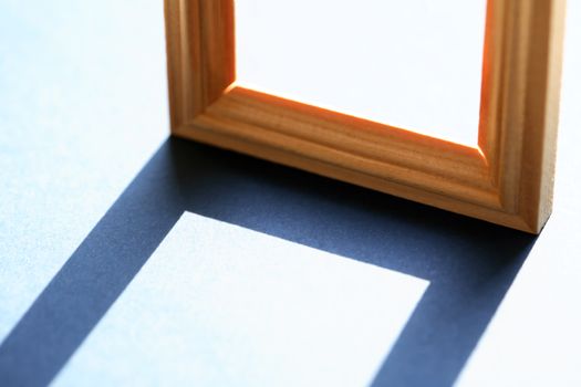 Empty wooden frame with long shadow against sunlight