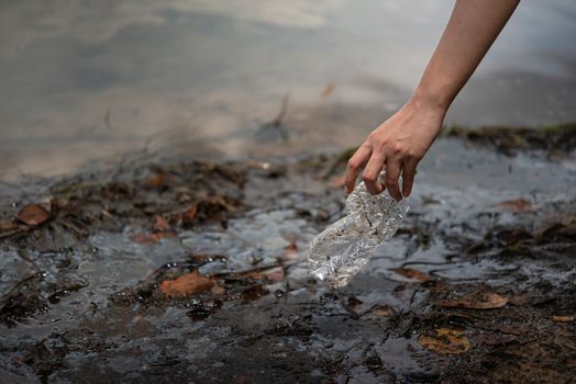 hand pick up plastic bottle from water. save environment and beat plastic pollution , Selective focus