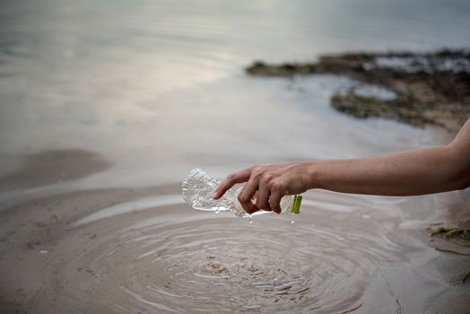 hand pick up plastic bottle from water. save environment and beat plastic pollution , Selective focus