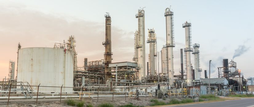 Panorama view typical oil refinery with smoke stacks gas flare at sunrise in Corpus Christi, Texas, America. Oil or gas production sites background