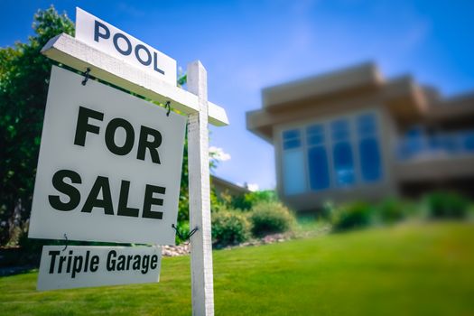 A Sale Sign For A Luxury Home With A Triple Garage And Swimming Pool In The Suburbs