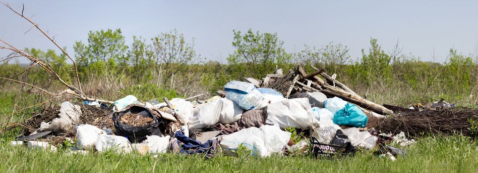 Panorama of a garbage dump in a field. Environmental pollution. Poverty. The global problem of humanity.