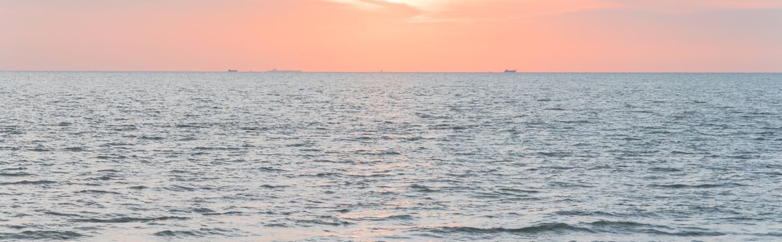 Panorama view scenery sunset on the beach of Melaka, Malaysia. Shipping boat and cruise can seen in the distance