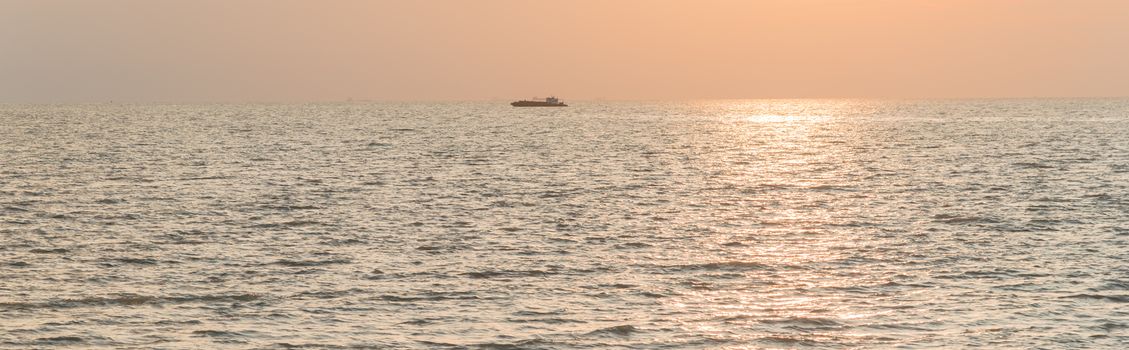 Panorama view scenery sunset on the beach of Melaka, Malaysia. Shipping boat and cruise can seen in the distance