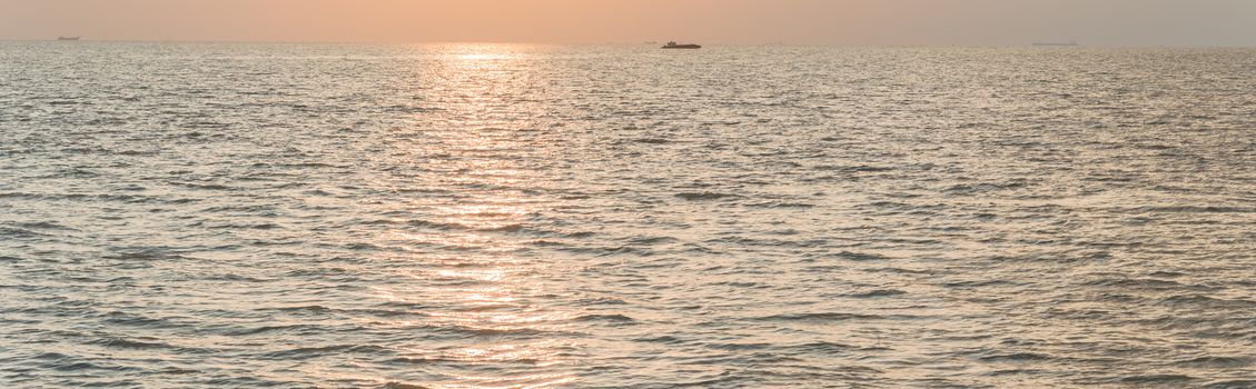 Panorama view scenery sunset on the beach of Melaka, Malaysia. Shipping boat and cruise can seen in the distance