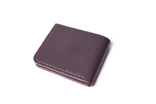 Brown handmade leather wallet isolated on white background. Wallet is closed. Stock photo of luxury businessman accessories.