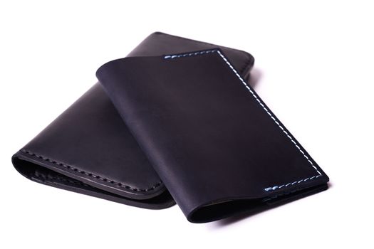 Black handmade leather man wallet and passport cover isolated on white background. Purse and cover are closed. Stock photo of luxury businessman accessories.