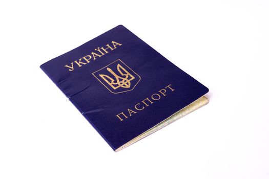 Blue Ukrainian passport isolated on white background. Passport is old and damaged a little bit. Stock photo of travel documents.