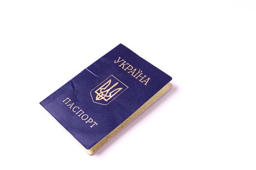 Blue Ukrainian passport isolated on white background. Passport is old and damaged a little bit. Stock photo of travel documents.