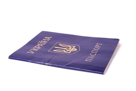 Blue Ukrainian passport isolated on white background. Passport is old and damaged a little bit and closed. Stock photo of travel documents.