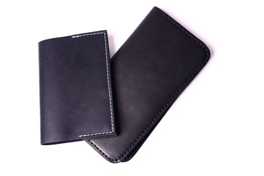 Black handmade leather man wallet and passport cover isolated on white background. Purse and cover are closed. Stock photo of luxury businessman accessories.