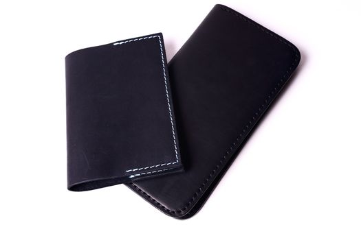 Black handmade leather man wallet and passport cover isolated on white background. Purse and cover are closed. Stock photo of luxury businessman accessories.