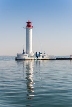 Lighthouse at the entrance to the harbor of the Odessa port, the sea gates of Ukraine in a sunny summer day