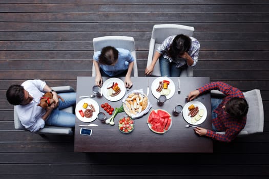 Four friends having dinner together, top view
