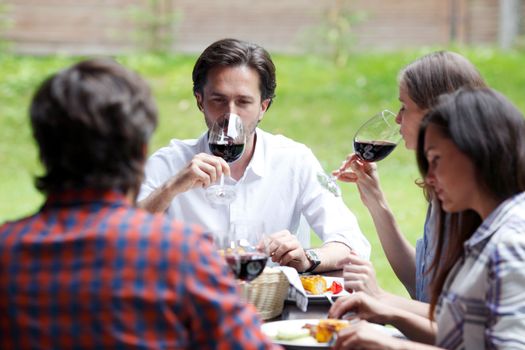 Friends drinking red wine at outdoor dinner
