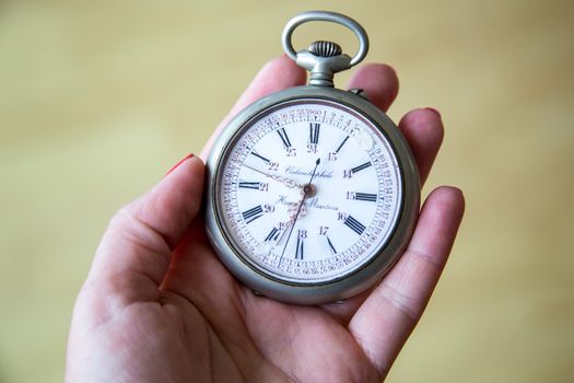 close up of hands with vintage pocket watch retro