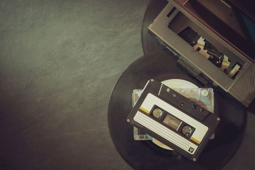 Cassette player and platter record on cement floor. Top view and copy space for text. Concept of vintage of music.