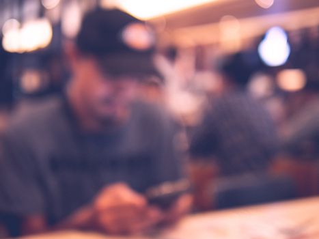 Defocus man using smartphone in restaurant or department store 
