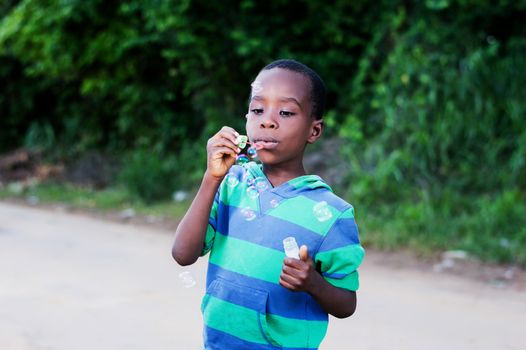Boy is having fun blowing bubbles.