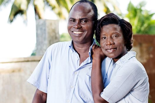 young young woman runs her husband by putting her hands on his  shoulder.